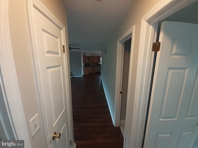 corridor with baseboards, dark wood-style flooring, and visible vents