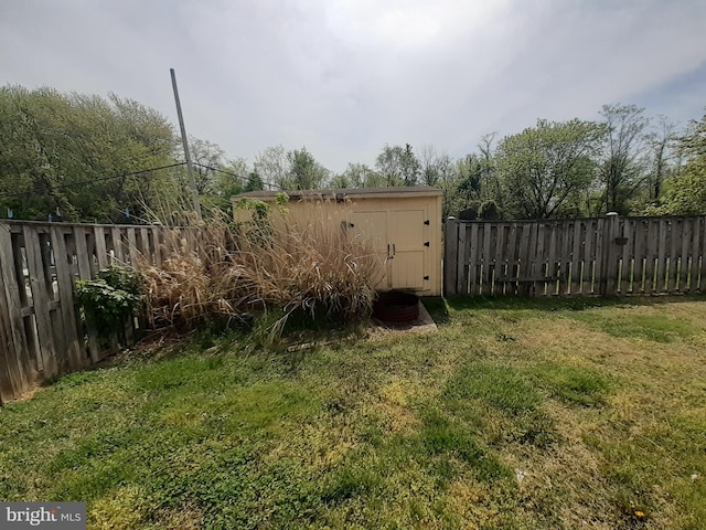 view of yard featuring an outbuilding, a fenced backyard, and a storage unit