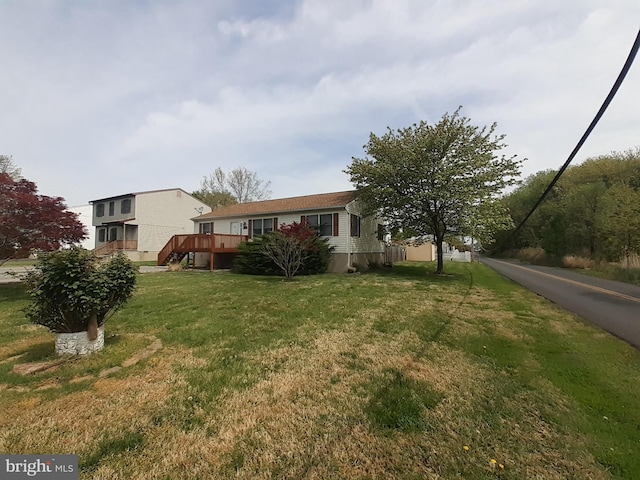 view of front of property featuring a deck and a front lawn