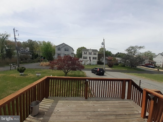 wooden deck with a yard and a residential view