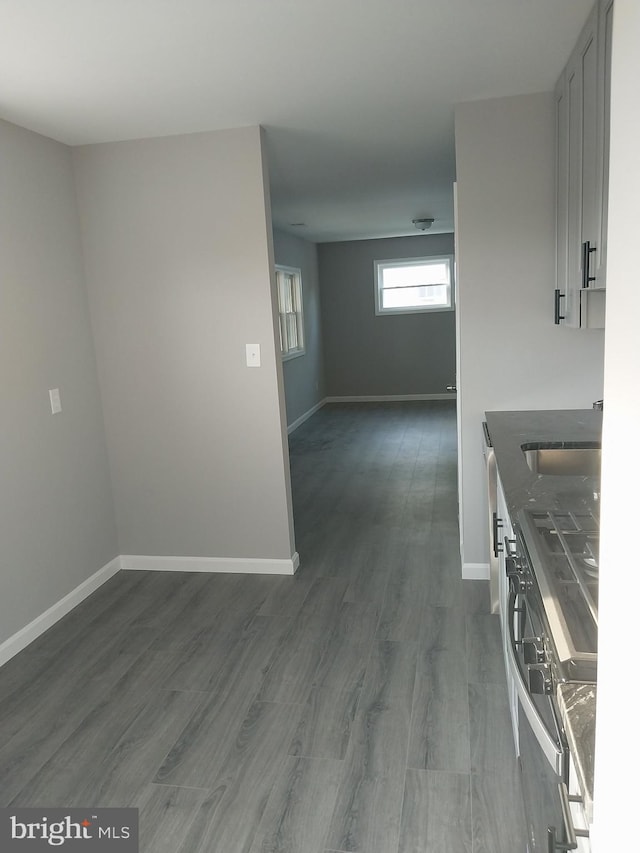 kitchen with dark countertops, baseboards, dark wood finished floors, and open floor plan