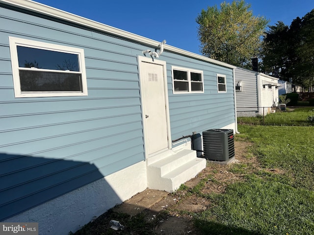 exterior space featuring a lawn, central AC, fence, and entry steps