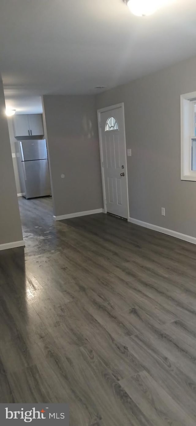 foyer entrance with baseboards and dark wood finished floors