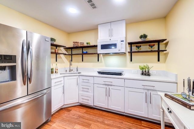 20662 Ashleaf Ct, Sterling, VA 20165 - kitchen with stainless steel refrigerator with ice dispenser, white microwave, open shelves, a sink, and light countertops
