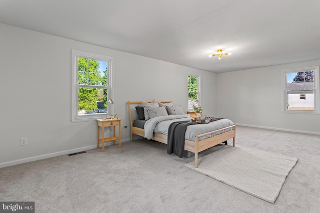 carpeted bedroom with visible vents and baseboards