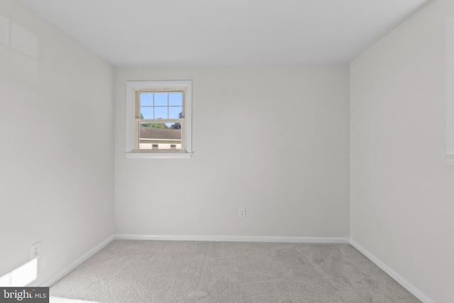 unfurnished room with light colored carpet and baseboards