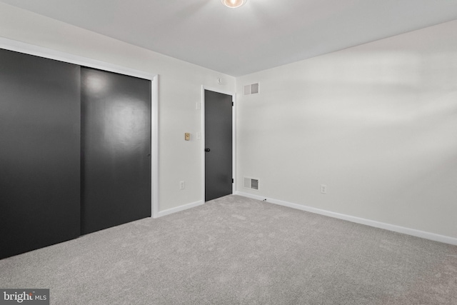 unfurnished bedroom featuring a closet, baseboards, carpet flooring, and visible vents
