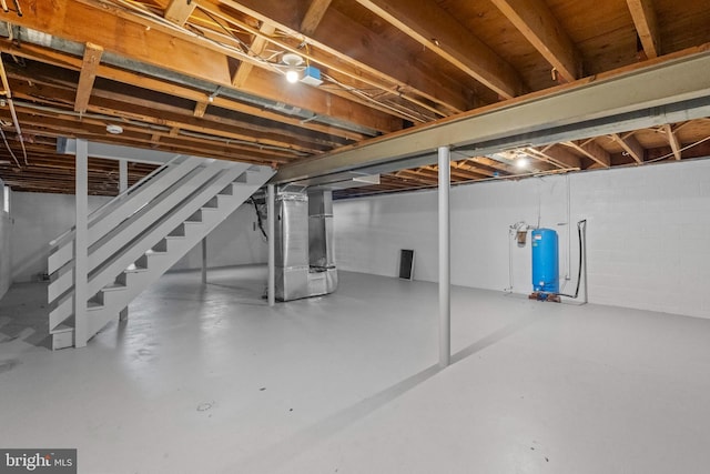 unfinished basement with heating unit and stairway