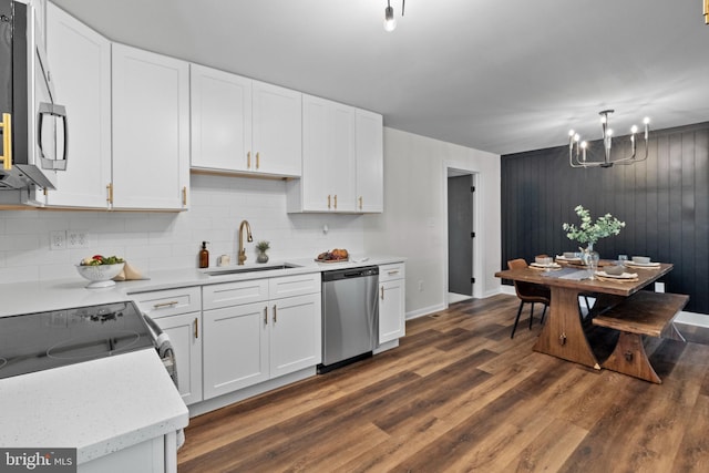 kitchen featuring stainless steel dishwasher, an inviting chandelier, dark wood-type flooring, white cabinetry, and a sink