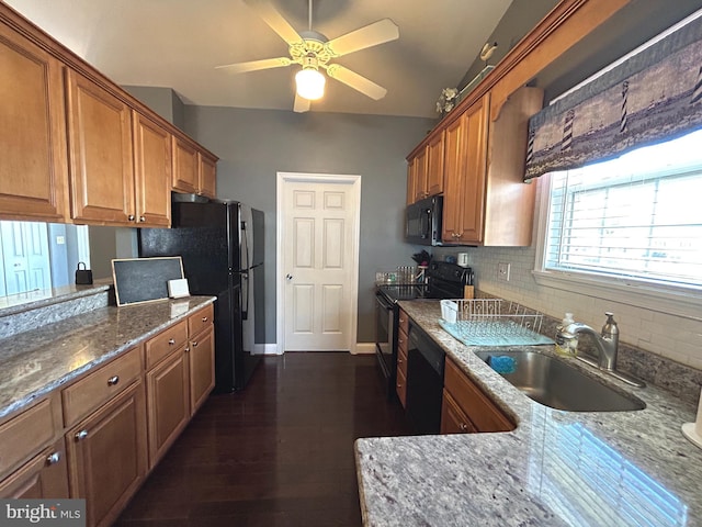 kitchen featuring a sink, decorative backsplash, black appliances, and brown cabinets