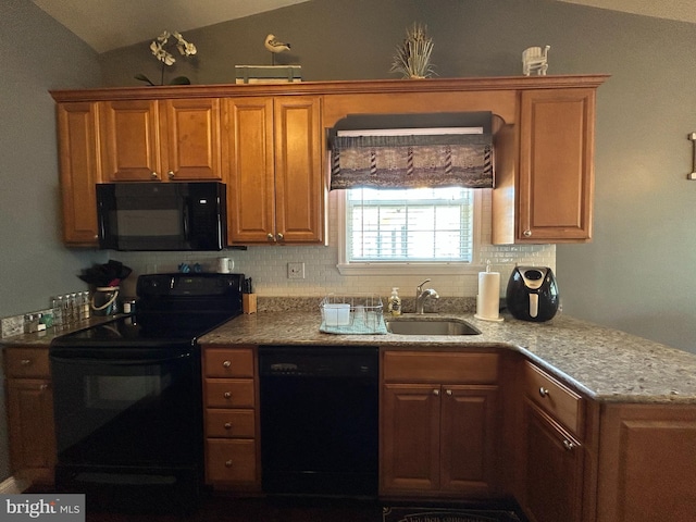 kitchen with brown cabinetry, a sink, backsplash, black appliances, and vaulted ceiling
