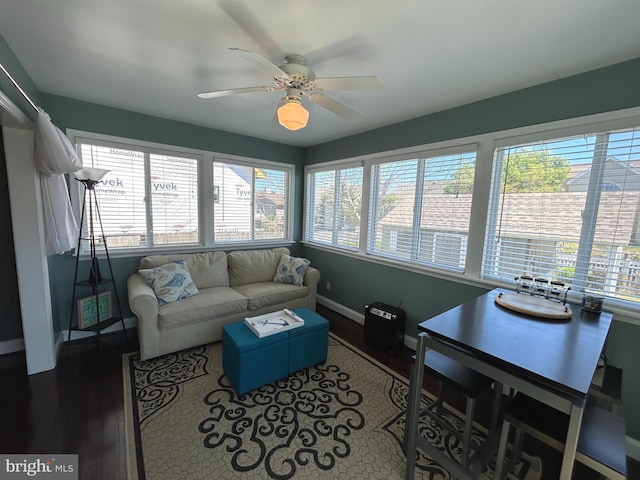 living area featuring a ceiling fan, wood finished floors, and a wealth of natural light