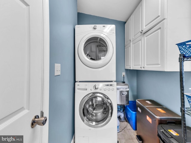 10350 Keyser Point Rd, Ocean City, MD 21842 - laundry room featuring stacked washer / dryer, cabinet space, and light tile patterned floors