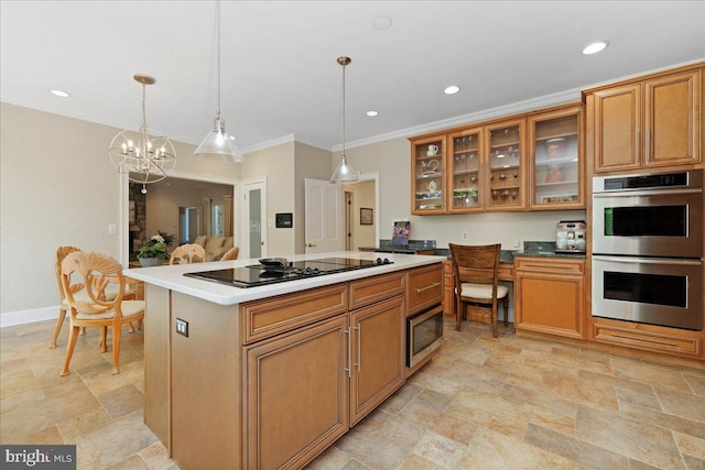 kitchen featuring brown cabinets, hanging light fixtures, black electric stovetop, double oven, and stone finish flooring