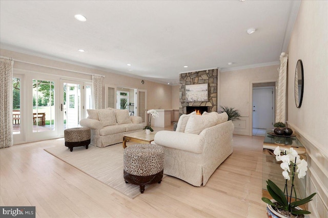 living area with crown molding, recessed lighting, light wood-style floors, and a fireplace