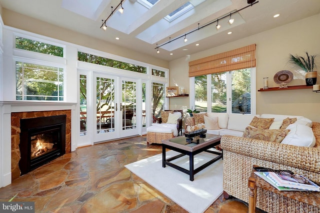 sunroom featuring rail lighting, a skylight, and french doors