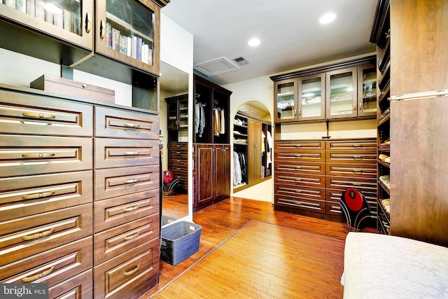 walk in closet with wood finished floors