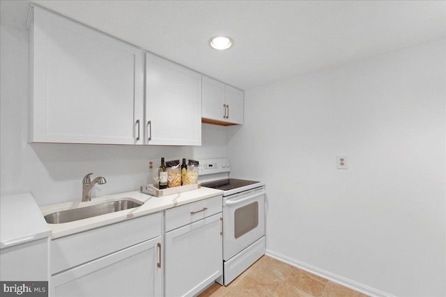 kitchen with white cabinets, white range with electric stovetop, a sink, light countertops, and baseboards