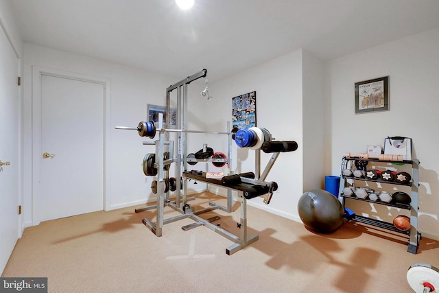 exercise area featuring baseboards and carpet