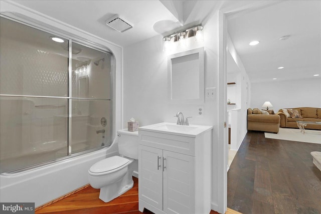 full bathroom with vanity, toilet, wood finished floors, and shower / bath combination with glass door