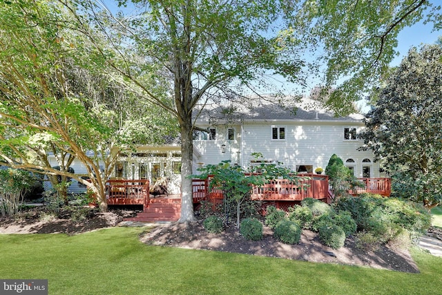 rear view of property with a yard and a wooden deck