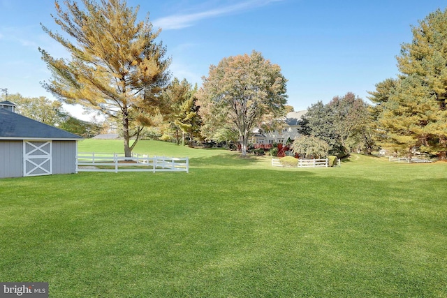 view of yard featuring fence and an outbuilding