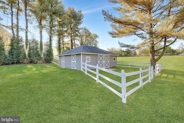 view of yard with fence, a barn, and an outbuilding