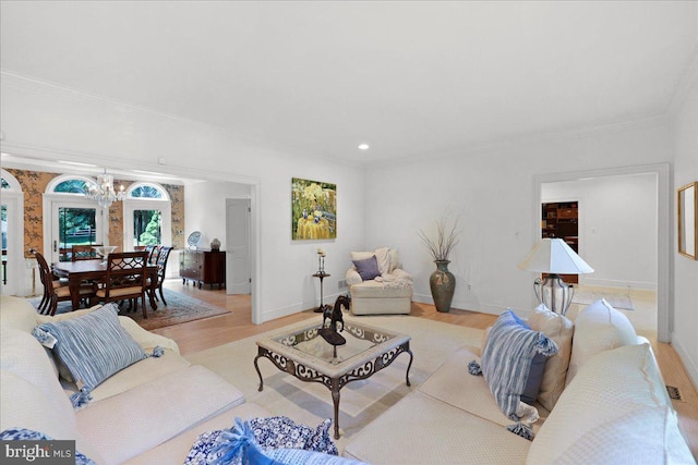 living room featuring crown molding, baseboards, light wood finished floors, an inviting chandelier, and recessed lighting