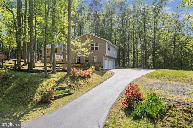 view of front facade with a garage, fence, driveway, and a front yard