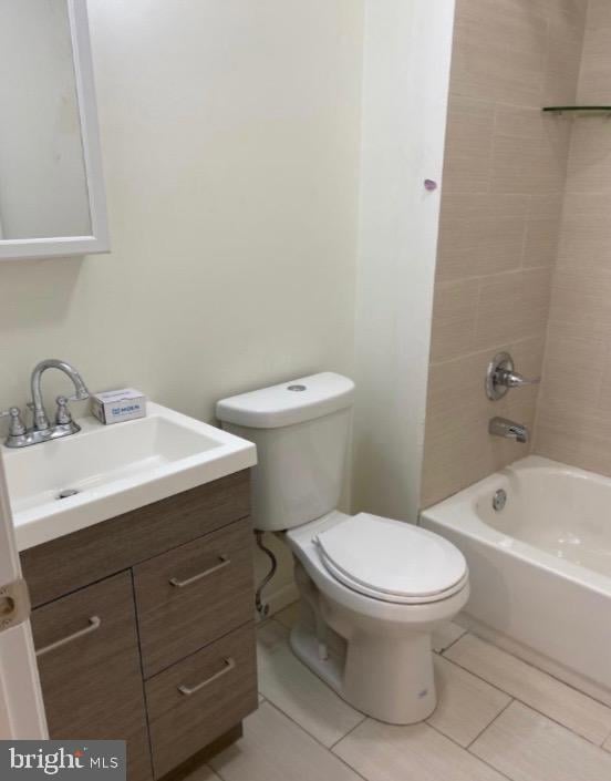 bathroom featuring toilet, washtub / shower combination, tile patterned flooring, and vanity