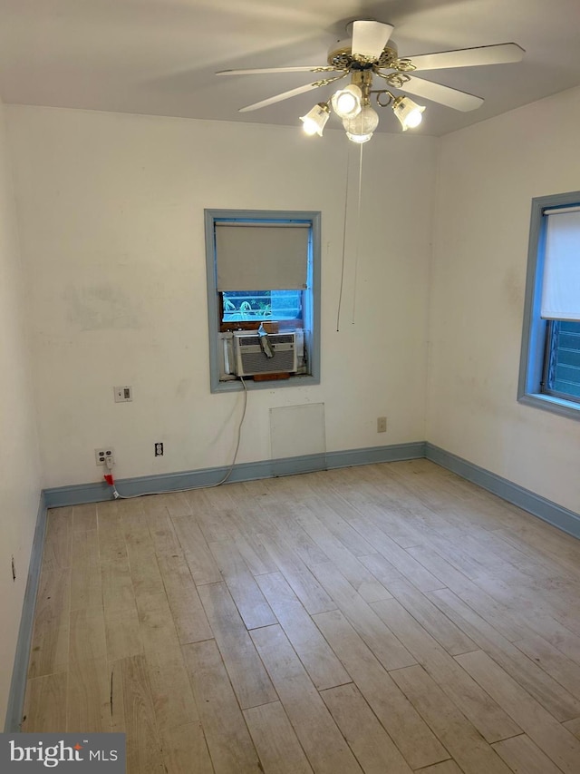 empty room with cooling unit, ceiling fan, wood finished floors, and baseboards