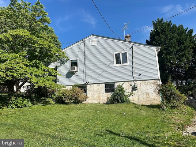 view of side of property with a chimney, a yard, and cooling unit