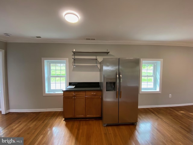 kitchen featuring dark countertops, stainless steel fridge, ornamental molding, and dark wood-type flooring