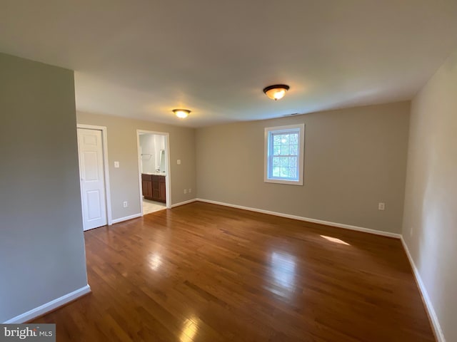 unfurnished room featuring dark wood-style flooring and baseboards