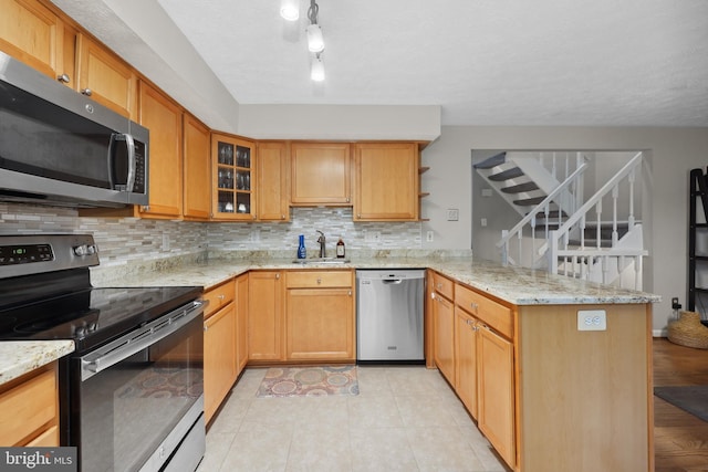 8140 Willowdale Ct, Springfield, VA 22153 - kitchen featuring stainless steel appliances, a peninsula, a sink, tasteful backsplash, and light stone counters