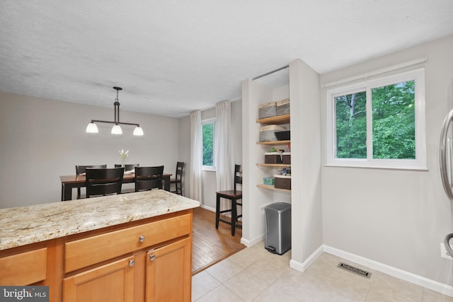 8140 Willowdale Ct, Springfield, VA 22153 - kitchen with baseboards, light tile patterned floors, hanging light fixtures, light stone countertops, and a textured ceiling