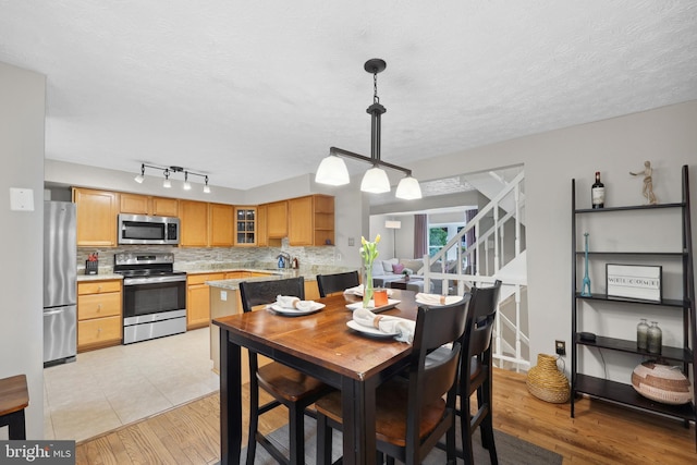 8140 Willowdale Ct, Springfield, VA 22153 - dining room with light wood finished floors, stairway, and a textured ceiling