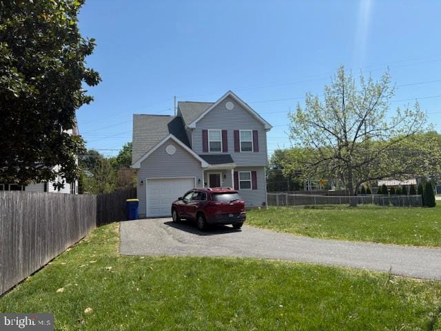 traditional home featuring fence, an attached garage, driveway, and a front lawn