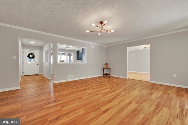 unfurnished living room with crown molding, a chandelier, light wood-style flooring, and visible vents
