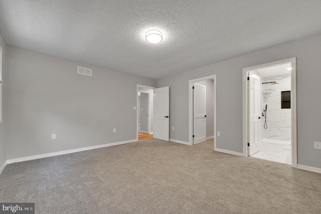 unfurnished bedroom featuring a textured ceiling, visible vents, baseboards, and carpet
