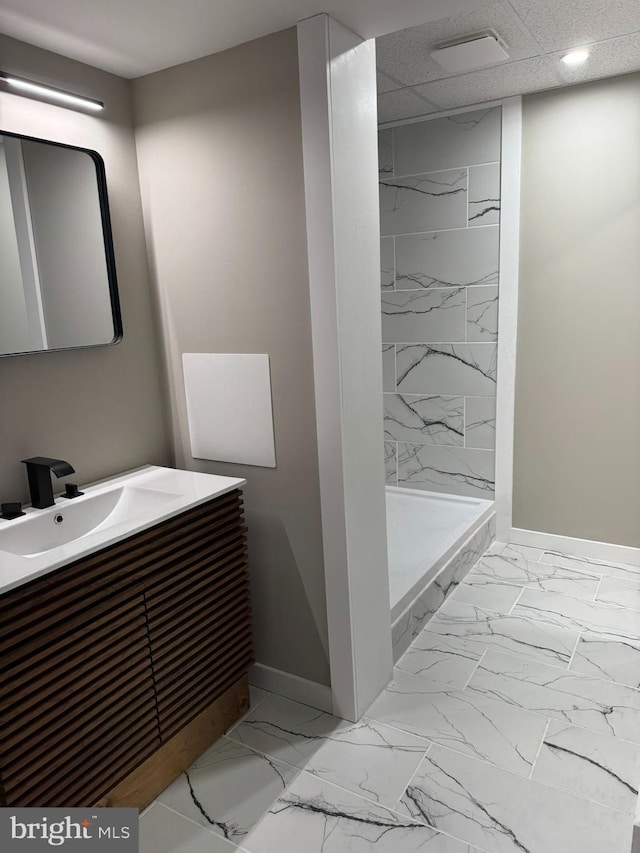 bathroom featuring baseboards, a shower stall, vanity, and marble finish floor