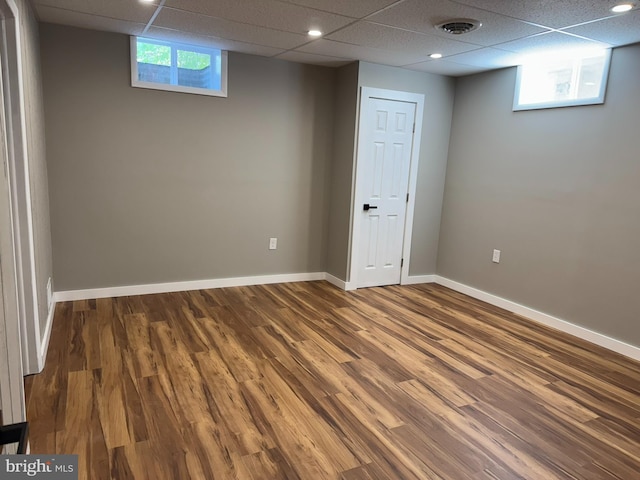 basement with baseboards, a drop ceiling, wood finished floors, and visible vents