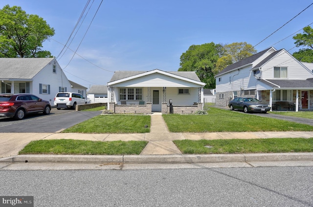 bungalow-style house featuring a porch and a front lawn
