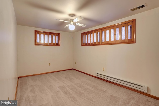 spare room with visible vents, light carpet, baseboards, ceiling fan, and baseboard heating