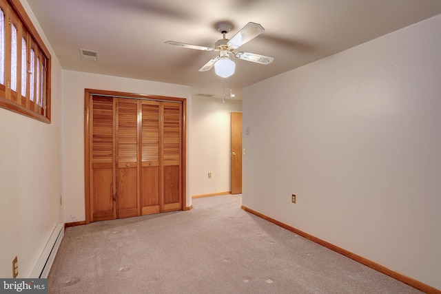 unfurnished bedroom with visible vents, light colored carpet, baseboards, a baseboard radiator, and a closet