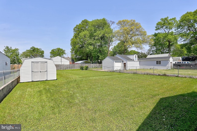 view of yard with a storage unit, a fenced backyard, and an outdoor structure