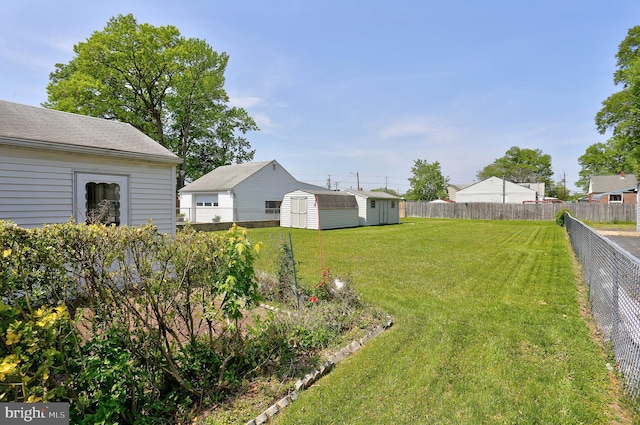 view of yard featuring an outdoor structure, a shed, and a fenced backyard