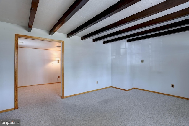 carpeted spare room featuring baseboards and beam ceiling