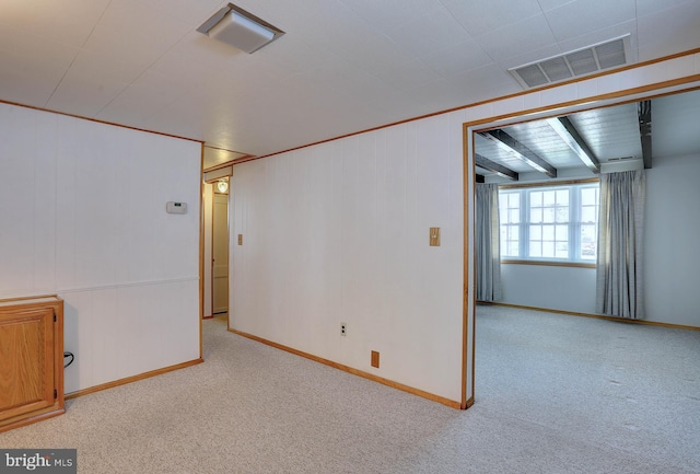 spare room featuring baseboards, visible vents, and carpet