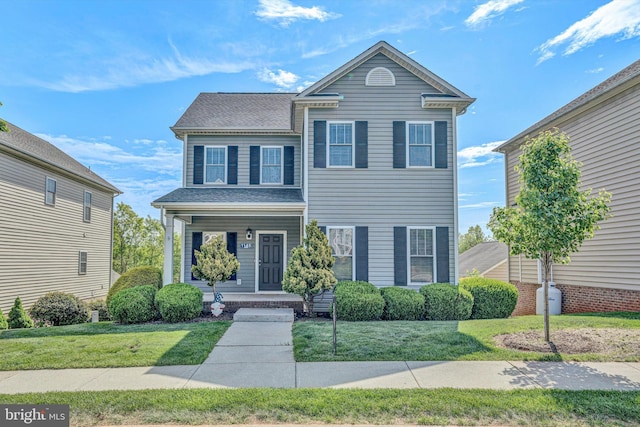 traditional-style home featuring a front lawn and covered porch